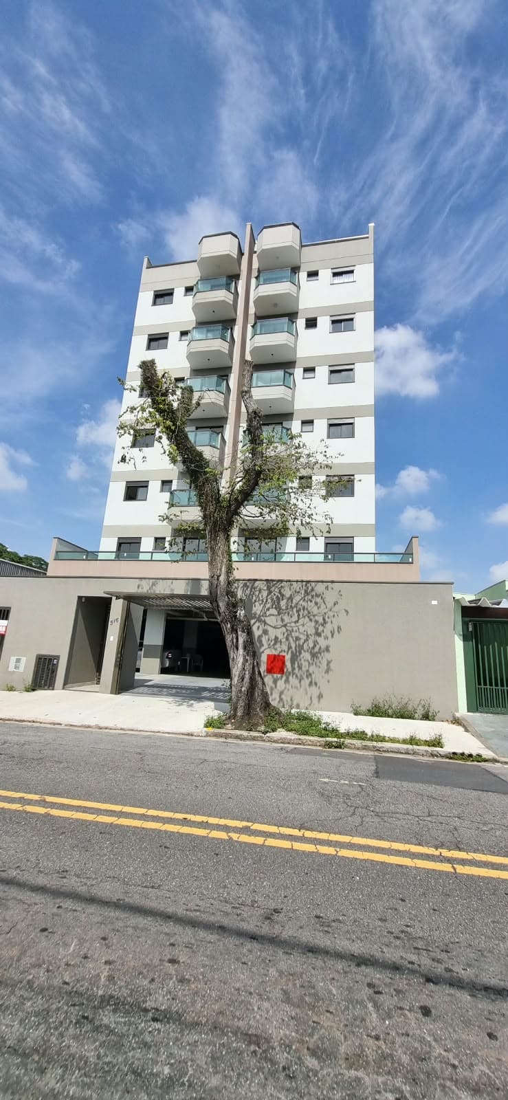 Edifício residencial de 8 pavimentos com fachada clara e varandas de vidro